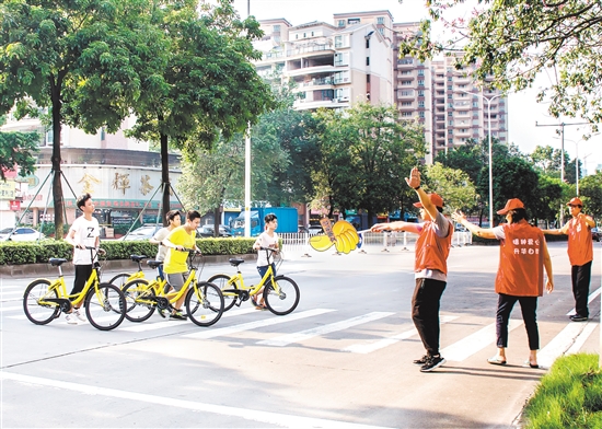 在志愿者的引导下,学生们有序通过马路。 在志愿者的引导下,学生们有序通过马路。